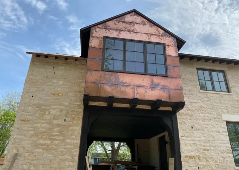 Copper metal panel facade on a stone building for Skylight Installation in Sterling
